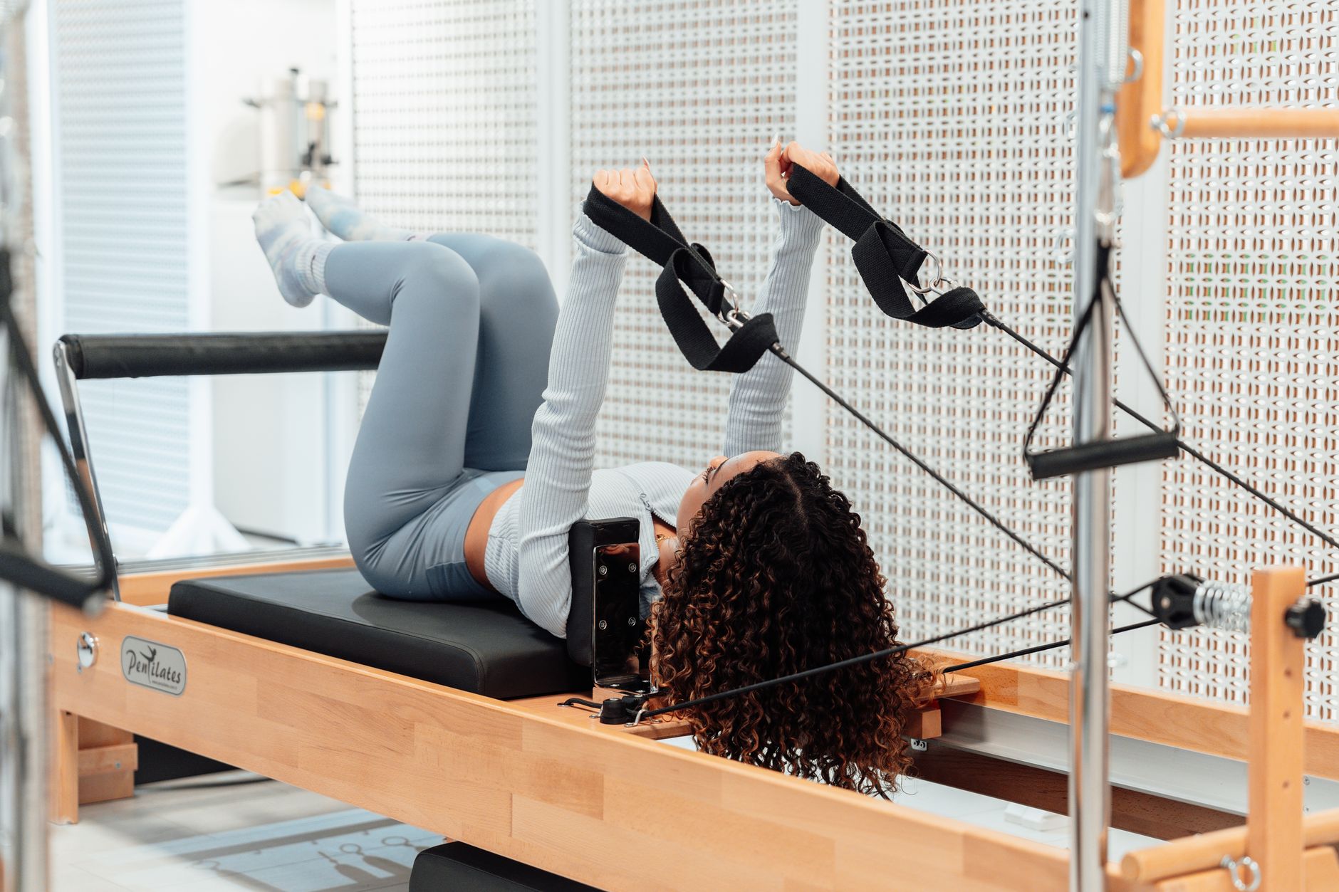 woman doing core pilates exercise on reformer