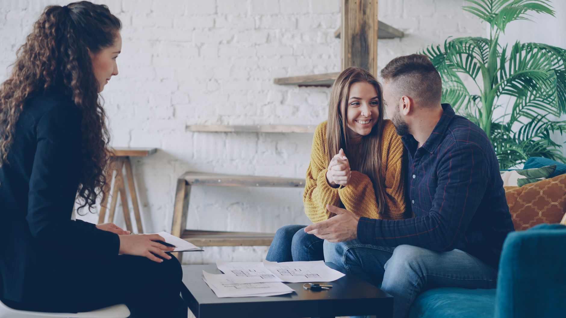 A smiling couple planning an event with a professional consultant in a cozy venu