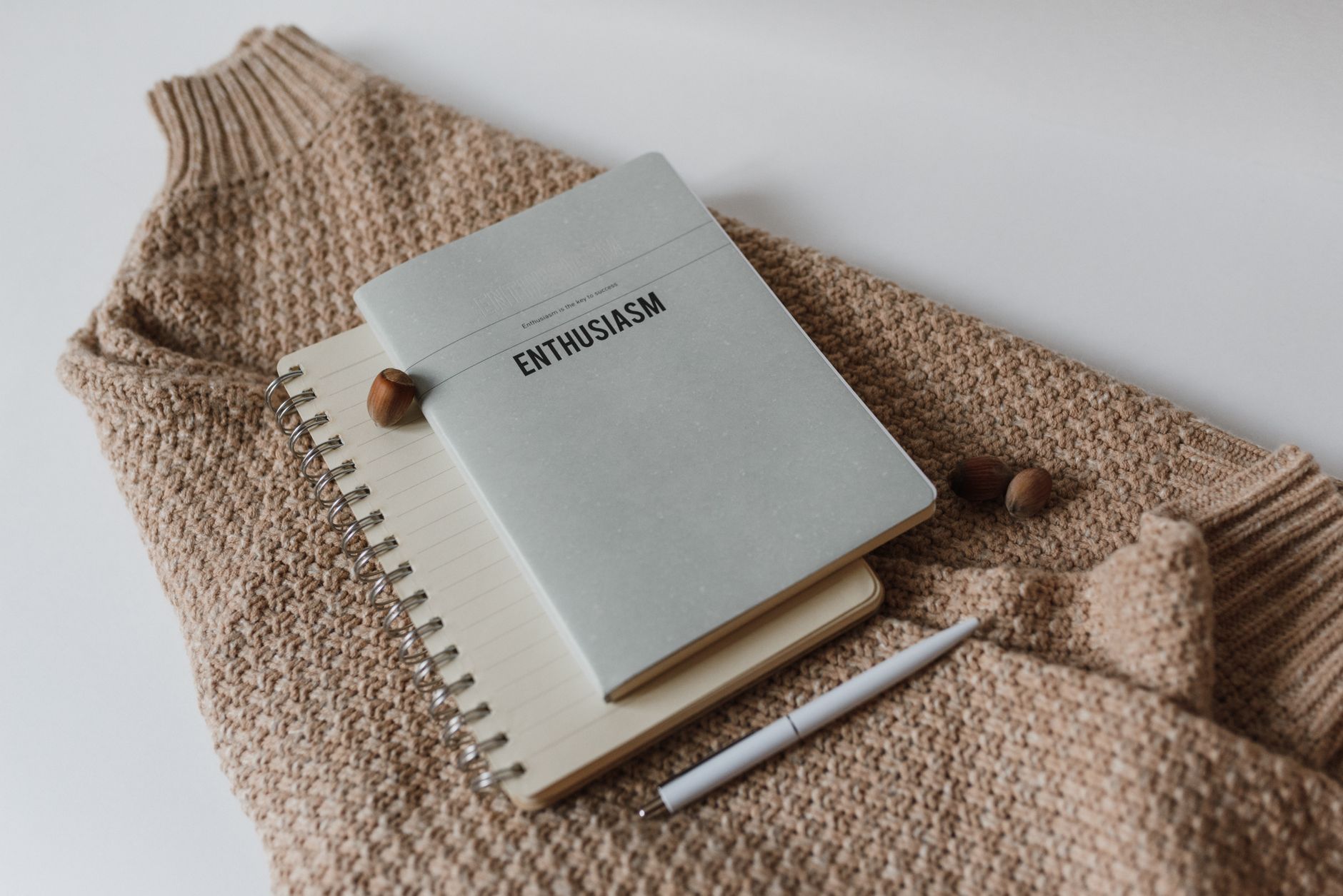 A cozy and minimalist event planning notebook with pens and flowers on a wooden