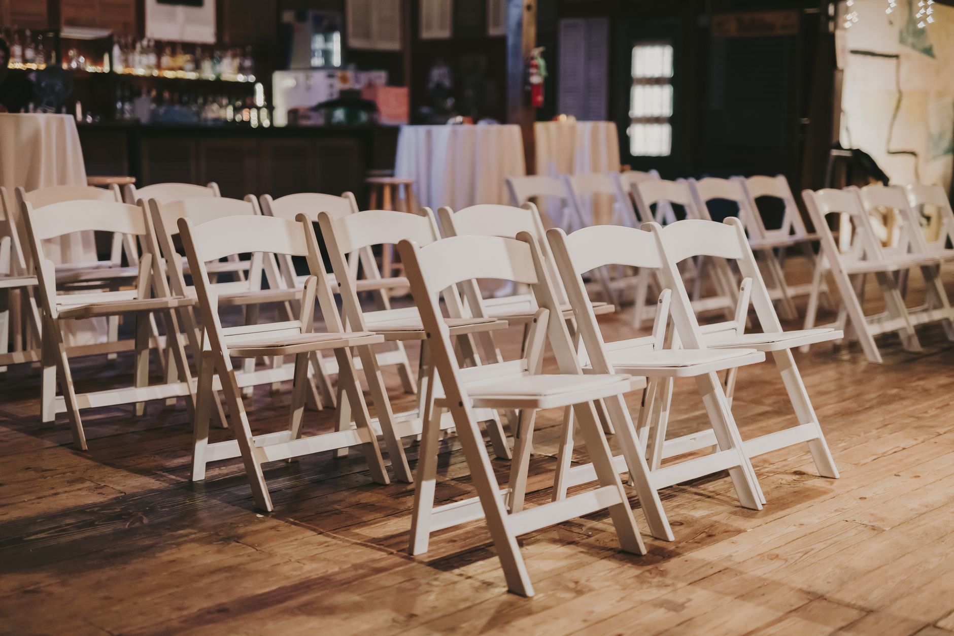 intimate decorated event space with white chairs and soft lighting