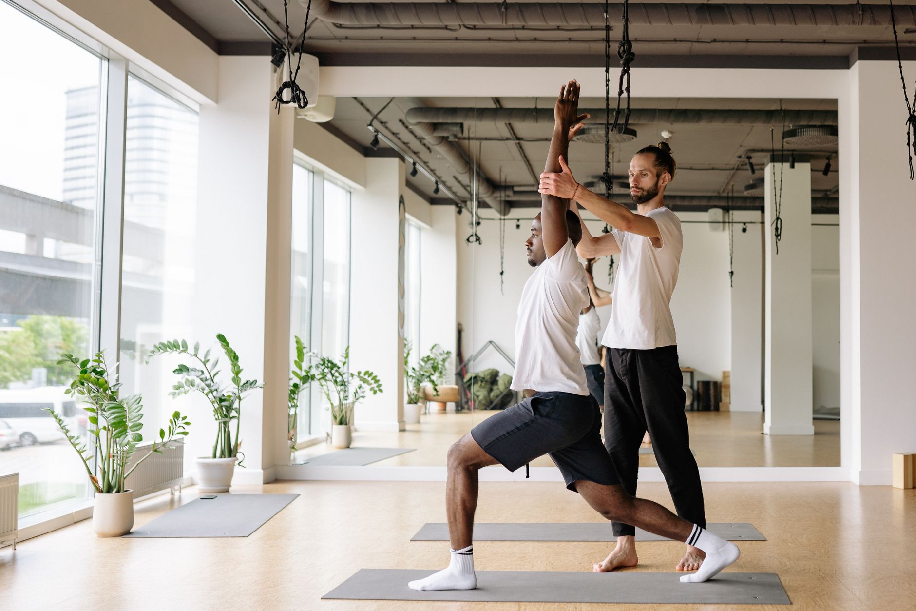 instructor teaching correct alignment to a student in a studio