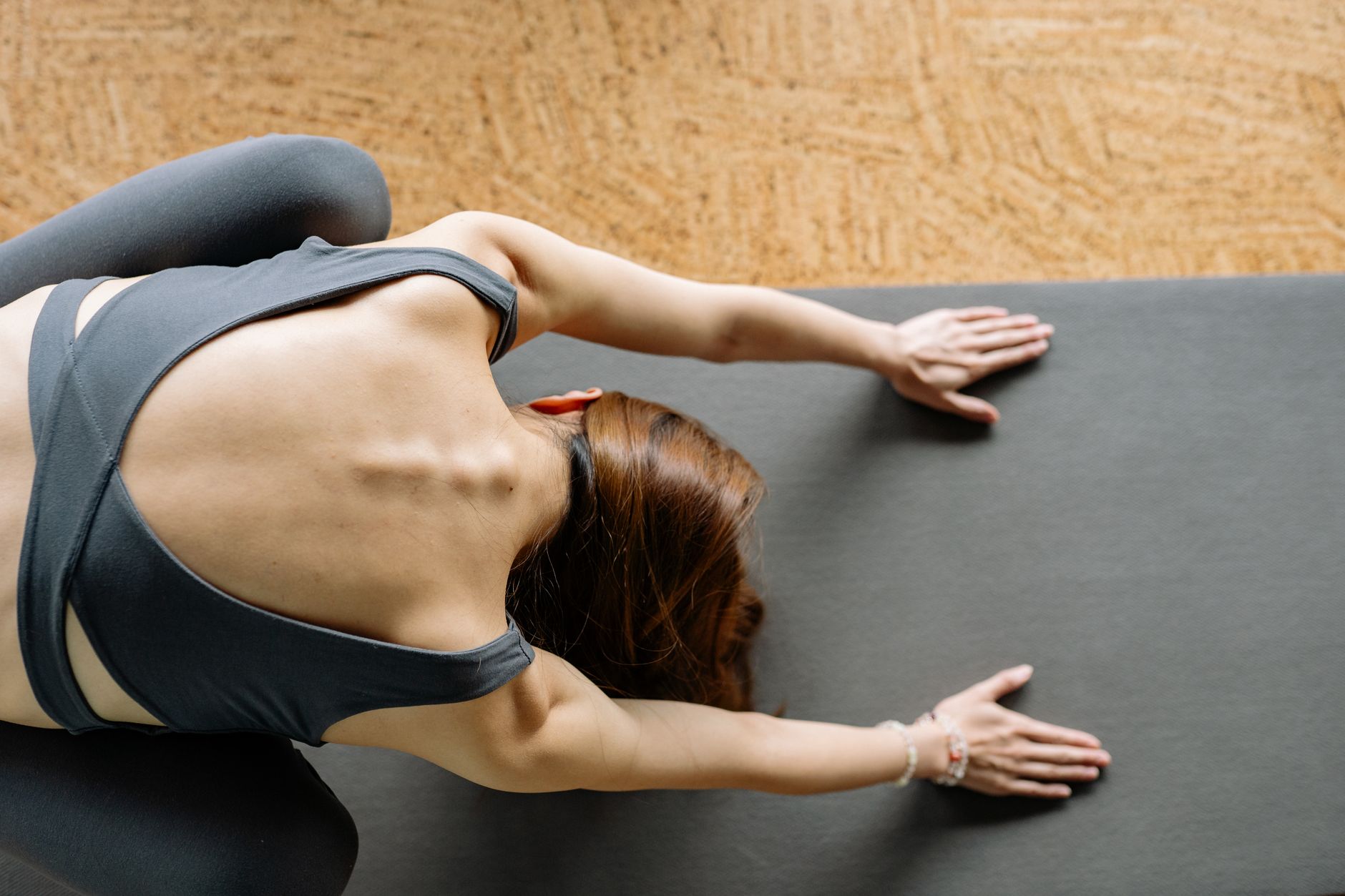 A person focusing on spinal alignment during a pilates exercise in a bright stud